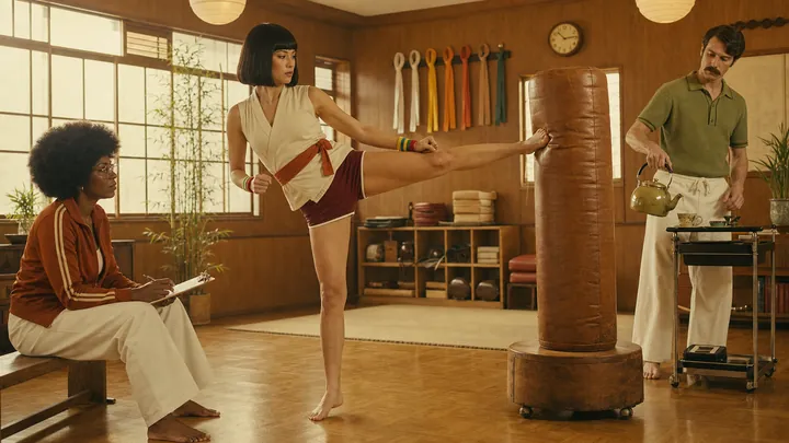 A martial arts student kicking a heavy bag